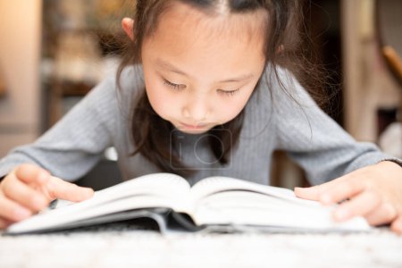 Photo for Girl reading a book seriously - Royalty Free Image