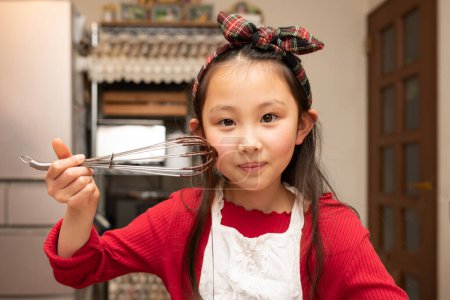 Téléchargez les photos : Une fille faisant des bonbons dans sa cuisine - en image libre de droit