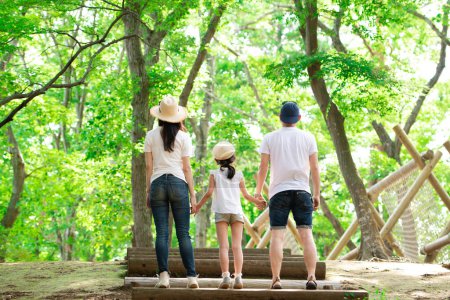 Téléchargez les photos : Père, mère et fille dans un parc forestier - en image libre de droit