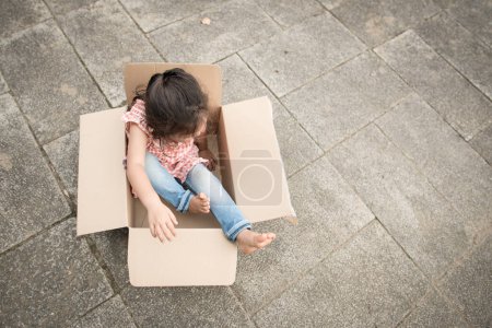 Photo for Girl playing in a cardboard box - Royalty Free Image