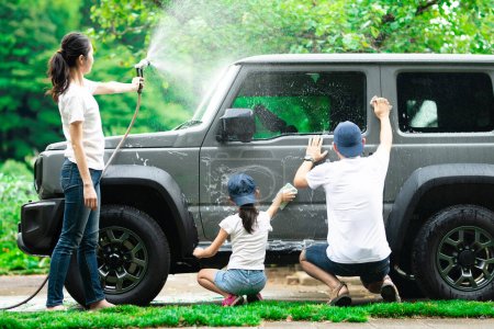 Téléchargez les photos : Père, mère et fille lavent la voiture - en image libre de droit