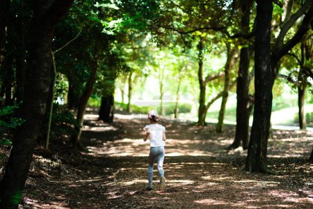 Téléchargez les photos : Fille courir dans le parc naturel - en image libre de droit