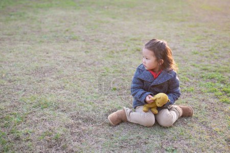 Téléchargez les photos : Asiatique enfant assis seul avec nounours - en image libre de droit