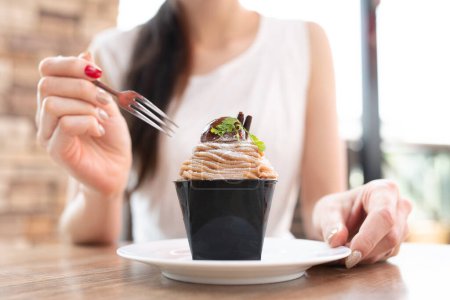 Téléchargez les photos : Femme mangeant sucré dans un café - en image libre de droit