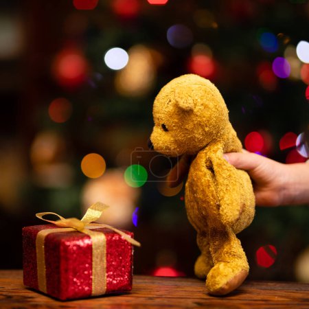 Foto de Manos de niños jugando con regalo de Navidad y osito de peluche - Imagen libre de derechos