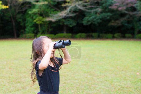 Téléchargez les photos : Fille jouer avec des jumelles à l'extérieur - en image libre de droit