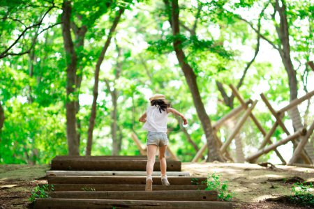 Téléchargez les photos : Fille monter les escaliers dans la forêt - en image libre de droit