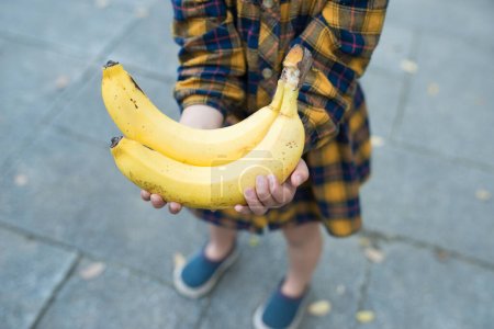 Niño con plátanos en las manos