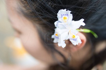 Foto de Primer plano de hermosa niña asiática con flor con fondo borroso. - Imagen libre de derechos