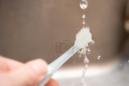 Téléchargez les photos : Lavez la brosse à dents avec de l'eau - en image libre de droit