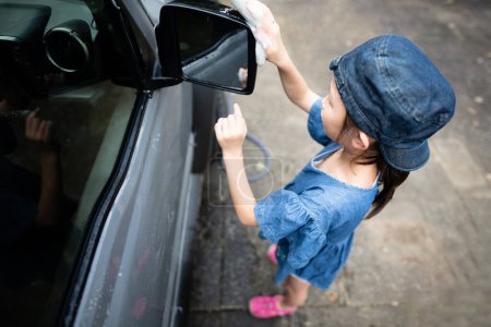 Photo for Girl washing a car with a sponge - Royalty Free Image