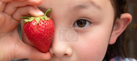 Photo for Asian child with red strawberry. - Royalty Free Image