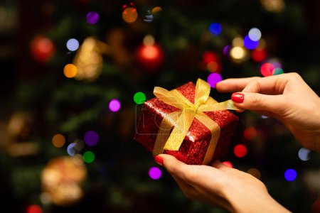 Téléchargez les photos : Les mains de la femme tenant un cadeau de Noël - en image libre de droit