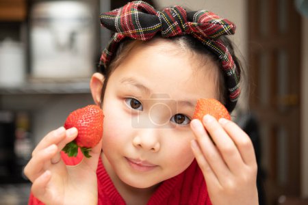 Téléchargez les photos : Enfant tient des fraises fraîches dans les mains - en image libre de droit