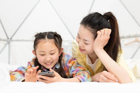 Téléchargez les photos : Mère et fille regardant smartphone - en image libre de droit