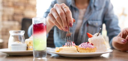 Téléchargez les photos : Femme mangeant des bonbons dans un restaurant - en image libre de droit