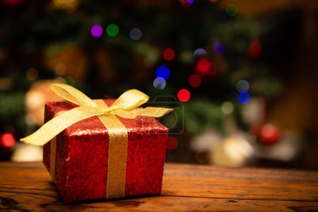 Téléchargez les photos : Cadeau de Noël placé devant le sapin de Noël - en image libre de droit