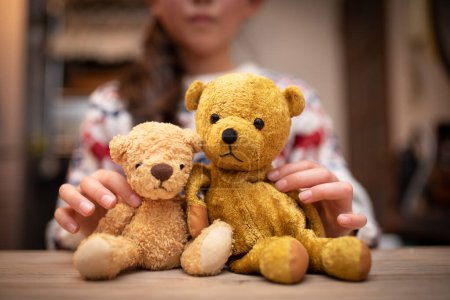 Téléchargez les photos : Un enfant jouant avec un ours en peluche et une boîte cadeau - en image libre de droit
