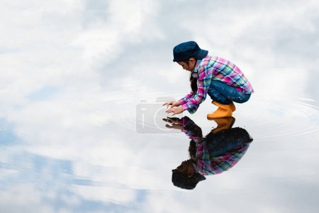 Photo for Child playing in a puddle - Royalty Free Image
