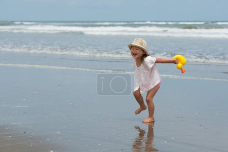 Foto de Niña jugando en la playa - Imagen libre de derechos
