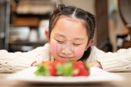Photo for Cute girl staring at strawberries - Royalty Free Image