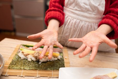 Foto de Manos de un niño haciendo rollos de sushi - Imagen libre de derechos
