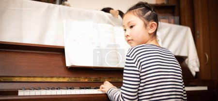 Photo for Girl playing the piano at home - Royalty Free Image