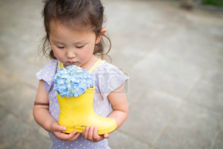 Photo for Girl with containing boot of hydrangea - Royalty Free Image