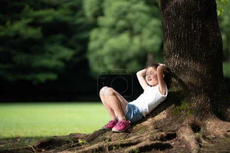 Téléchargez les photos : Fille se détendre à l'ombre d'un arbre - en image libre de droit