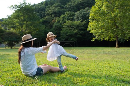 Téléchargez les photos : Mère et fille jouant dans la pelouse - en image libre de droit