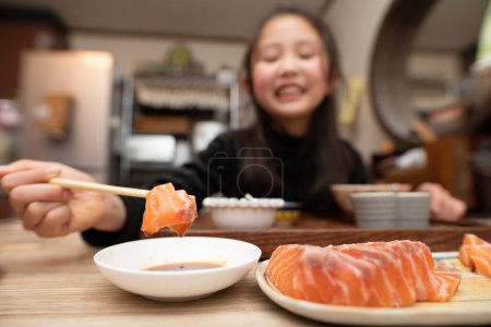 Téléchargez les photos : Fille manger sashimi avec des baguettes - en image libre de droit