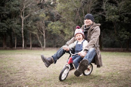 Photo for Father with dauther on riding bicycle in park - Royalty Free Image