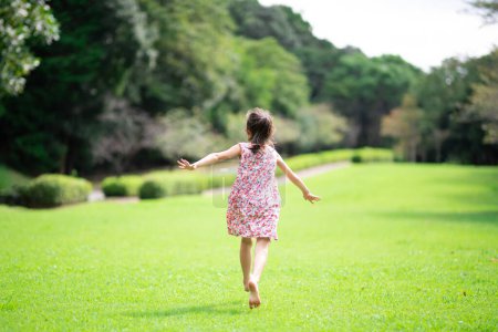 Téléchargez les photos : Fille jouant pieds nus sur la pelouse - en image libre de droit