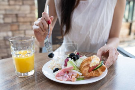 Foto de Mujer comiendo sabrosa comida en la cafetería - Imagen libre de derechos