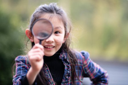 Photo for Girl playing with a magnifying glass - Royalty Free Image