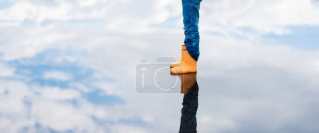 Photo for Feet of a child playing in a puddle - Royalty Free Image