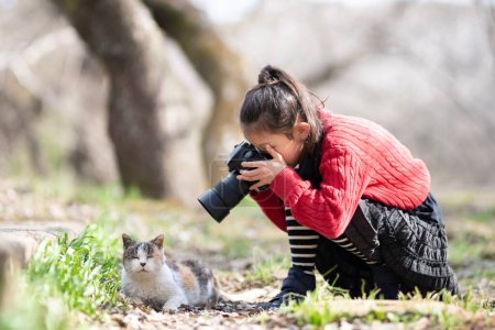 Téléchargez les photos : Fille prenant des photos de chat - en image libre de droit