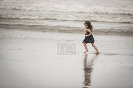 Photo for Girl playing on the beach - Royalty Free Image