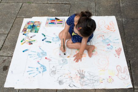 Foto de Chica pintura sobre papel al aire libre - Imagen libre de derechos