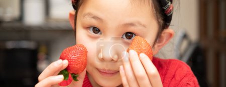 Photo for Child holds fresh strawberries in hands - Royalty Free Image