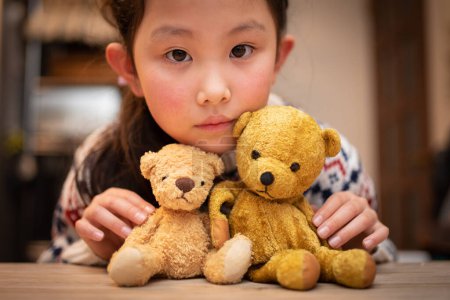 Foto de Un niño jugando con un oso de peluche y una caja regalo - Imagen libre de derechos