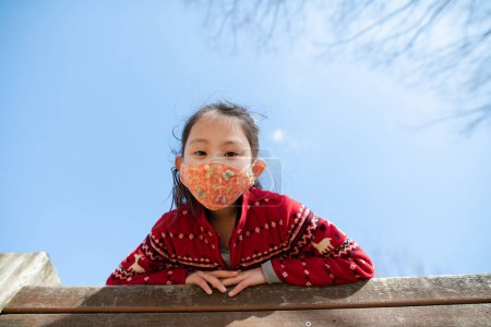 Téléchargez les photos : Fille portant un masque jouant dans un parc d'hiver - en image libre de droit