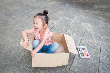 Foto de Chica jugando en una caja de cartón - Imagen libre de derechos