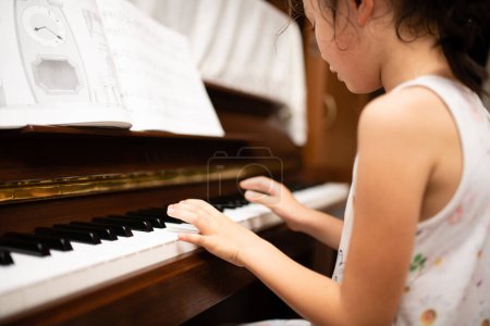 Téléchargez les photos : Fille pratiquant le piano dans la chambre - en image libre de droit