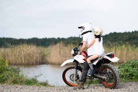 Father and daughter riding two seater off road bike 