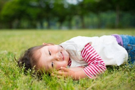 Téléchargez les photos : Fille jouer dans l'herbe - en image libre de droit