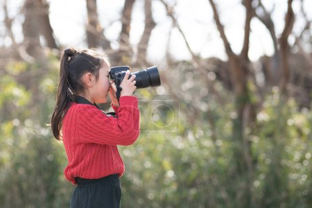Foto de Una chica tomando una foto con una cámara réflex de lente única - Imagen libre de derechos