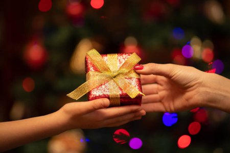 Photo for Parent and child handing Christmas gifts - Royalty Free Image