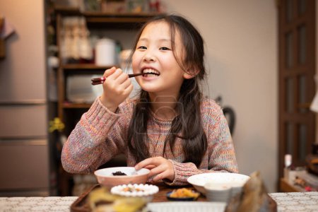 Téléchargez les photos : Fille à manger avec des baguettes - en image libre de droit
