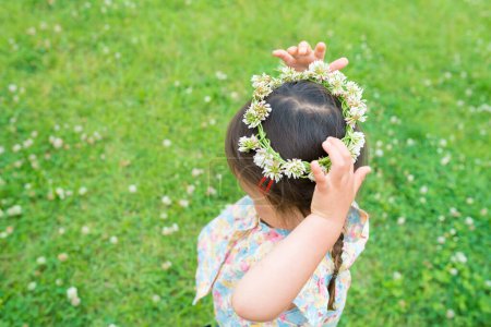 Téléchargez les photos : Fille jouer et porter une couronne de fleurs - en image libre de droit